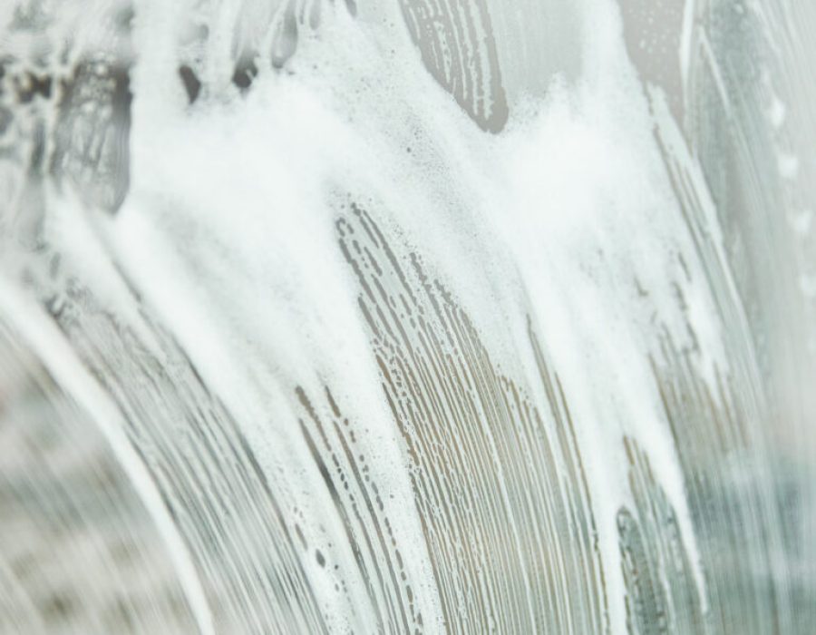 White soap foam texture background in bathroom. Cleaning concept